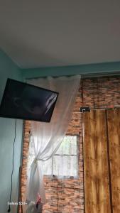a window with a white curtain and a television at Garsoniere Leka in Pogradec