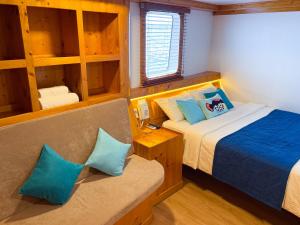 ein kleines Zimmer mit einem Bett und einer Couch darin in der Unterkunft Ritrella Floating Hotel in Male City + 29 Fotos