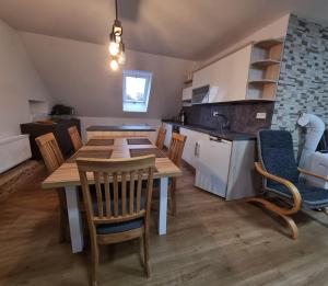 a kitchen with a wooden table and chairs in a room at Apartmán Jana in Vysoké Mýto