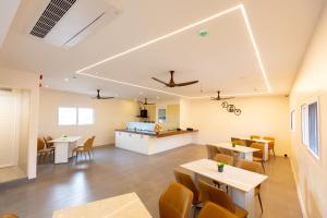 uma sala com mesas e cadeiras e uma cozinha em Kaizen Residency Trichy em Tiruchchirappalli