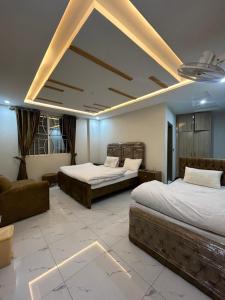 un dormitorio con dos camas y un sofá en askari lodges, en Murree