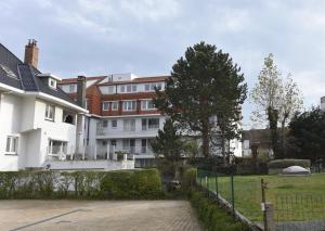 een wit huis met een hek voor een tuin bij Studio Ocean by BLOSS, luxe studio in Knokke in Knokke-Heist