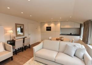 een woonkamer met een witte bank en een tafel bij Studio Ocean by BLOSS, luxe studio in Knokke in Knokke-Heist