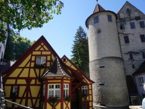 un edificio con una torre accanto a un castello di Pension Ins Fischernetz - Mäntele a Meersburg