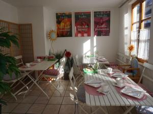 ein Zimmer mit Tischen, Stühlen und Plakaten an der Wand in der Unterkunft Pension Ins Fischernetz - Mäntele in Meersburg
