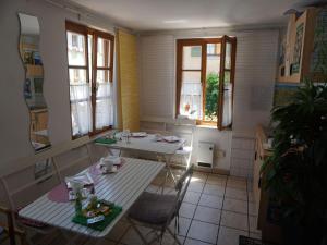 a small kitchen with a table and chairs and windows at Pension Ins Fischernetz - Mäntele in Meersburg