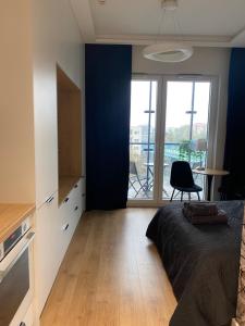 a bedroom with a bed and a desk and a window at Chillout Luxury Touch Apartment - Free Parking Wola Tower in Warsaw +8 photos