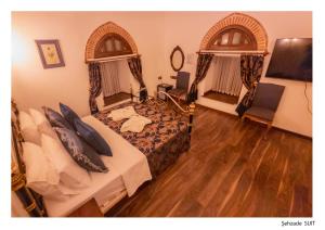 a bedroom with a bed and two arched windows at Kervansaray Antique Hotel in Cesme