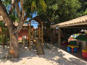 une aire de jeux avec un arbre et une balançoire dans l'établissement Chalé das flores, à Maceió