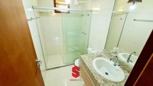 a bathroom with a sink and a shower with a mirror at Chalé das flores in Maceió
