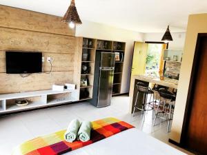 a kitchen with a refrigerator and a counter with a bar at Chalé das flores in Maceió