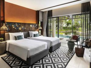 a hotel room with two beds and a pool at Grand Mercure Khao Lak Bangsak in Khao Lak +160 photos