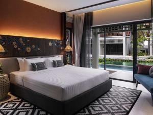 a bedroom with a large bed and a swimming pool at Grand Mercure Khao Lak Bangsak in Khao Lak +142 photos