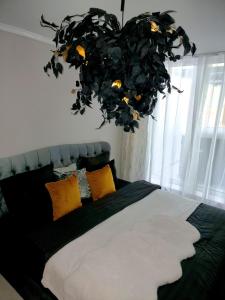 a bedroom with a large bed with yellow pillows at GLAMOUR VOX Jacuzzi & Club in Cluj-Napoca