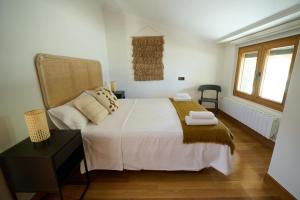 une chambre avec un grand lit blanc avec des serviettes dessus dans l'établissement Tanbolin, à Gautegiz Arteaga