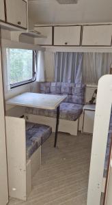 an interior of an rv with a table and a couch at Beheizter Wohnwagen mit Küche und Duschbad in Berlin