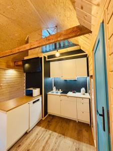 a kitchen with white cabinets and a wooden ceiling at Apartament z antresolą Igły i Szyszki in Jeleniewo