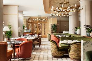 a restaurant with tables and chairs and a chandelier at Montcalm Mayfair, Autograph Collection in London