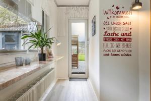 カロリーネンジールにあるFerienwohnung KUMM RIN - Oase an der Nordseeの壁に看板を付けた廊下 +10枚の写真