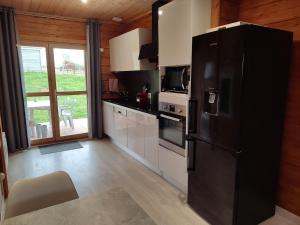 a kitchen with a black refrigerator in a room at Chalet ICARE in Saint-Rémy-du-Nord
