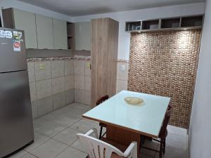 a kitchen with a table and a refrigerator at Casa Ribeiro in Canguçu +7 photos
