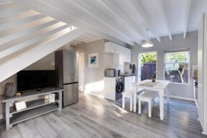 a living room with a kitchen and a dining room table at Chive Cottage in Cape St Francis