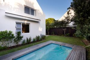 a backyard with a swimming pool and a house at Chive Cottage in Cape St Francis