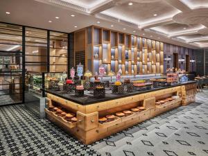 a bakery with a counter with cakes and pastries at Fairmont Chengdu in Chengdu
