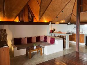 a living room with a couch and a kitchen at The Place Luxury Boutique Villas in Koh Tao