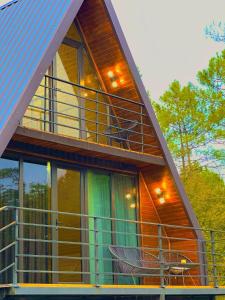 ein Haus mit einem Balkon mit Stühlen darauf in der Unterkunft Cozy wooden cottage in the forest 2 km from Kutais in Kutaissi