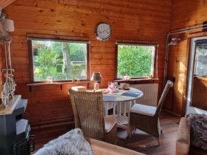 a dining room with a table and two windows at Prieelhoeve in Almere
