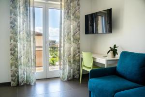 a living room with a blue couch and a desk and a window at hiPaestum in Paestum