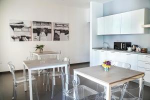 two tables and chairs in a kitchen with white cabinets at hiPaestum in Paestum