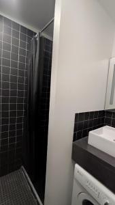 ein Bad mit einem schwarzen Duschvorhang und einem Waschbecken in der Unterkunft Gentianes 6 in La Norma + 2 Fotos