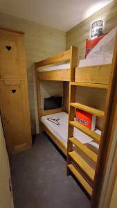 ein kleines Zimmer mit zwei Etagenbetten und einem Schrank in der Unterkunft Gentianes 6 in La Norma