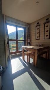 ein Raum mit einem Tisch und einem großen Fenster in der Unterkunft Gentianes 6 in La Norma