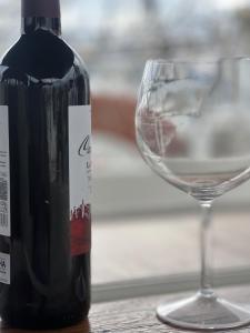 una botella de vino junto a una copa de vino en Exclusive Unique Experience on a Sailboat All Year Round TNINA, en Valencia