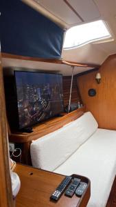 Una habitación con televisión y mandos a distancia en un barco. en Exclusive Unique Experience on a Sailboat All Year Round TNINA, en Valencia