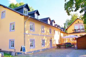a large yellow building with a patio in front of it at Hotel Alttolkewitzer Hof in Dresden