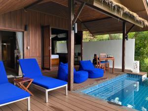 a villa with a pool and a deck with blue chairs at The Place Luxury Boutique Villas in Koh Tao