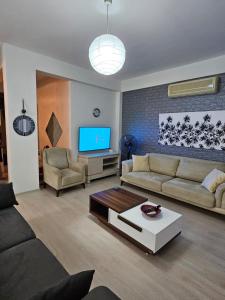 a living room with a couch and a tv at Kyrenia Turtle Village Sea Villa with Garden in Kérynia