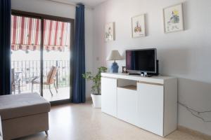 soggiorno con TV su un armadietto bianco di Ático con vistas a Port Saplaya