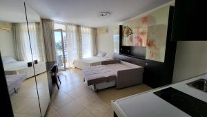 a living room with two beds and a television at Studio F210 - Bulharsko in Aheloy +26 photos
