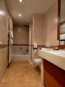 a bathroom with a toilet and a sink and a tub at Hotel De Notelaer in Bornem