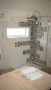 a bathroom with two towels on a bed and a shower at Le Refuge Des Saisons  +15 photos