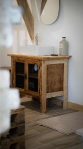 a bathroom vanity with a sink and a mirror at Le Refuge Des Saisons 