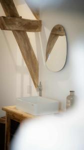 a bathroom with a white sink and a mirror at Le Refuge Des Saisons in Barisis-aux-Bois