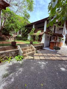 a house with stairs and a porch at Emma's Sea View in Hiriketiya