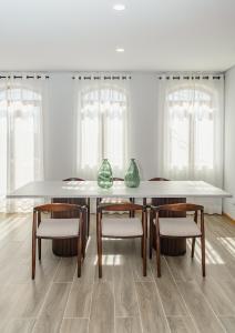 einen Esstisch mit Stühlen und Vasen darauf in der Unterkunft LR Vintage 65 in Vila Real