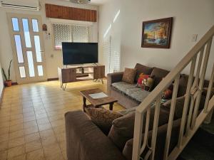un salon avec un canapé et une télévision à écran plat dans l'établissement Alquiler temporario en zona centrica de San Nicolas De Los Arroyos, à San Nicolás de los Arroyos